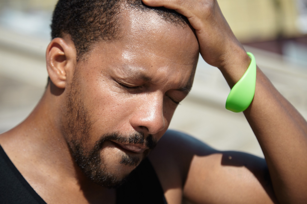A man wipes sweat off his forehead.