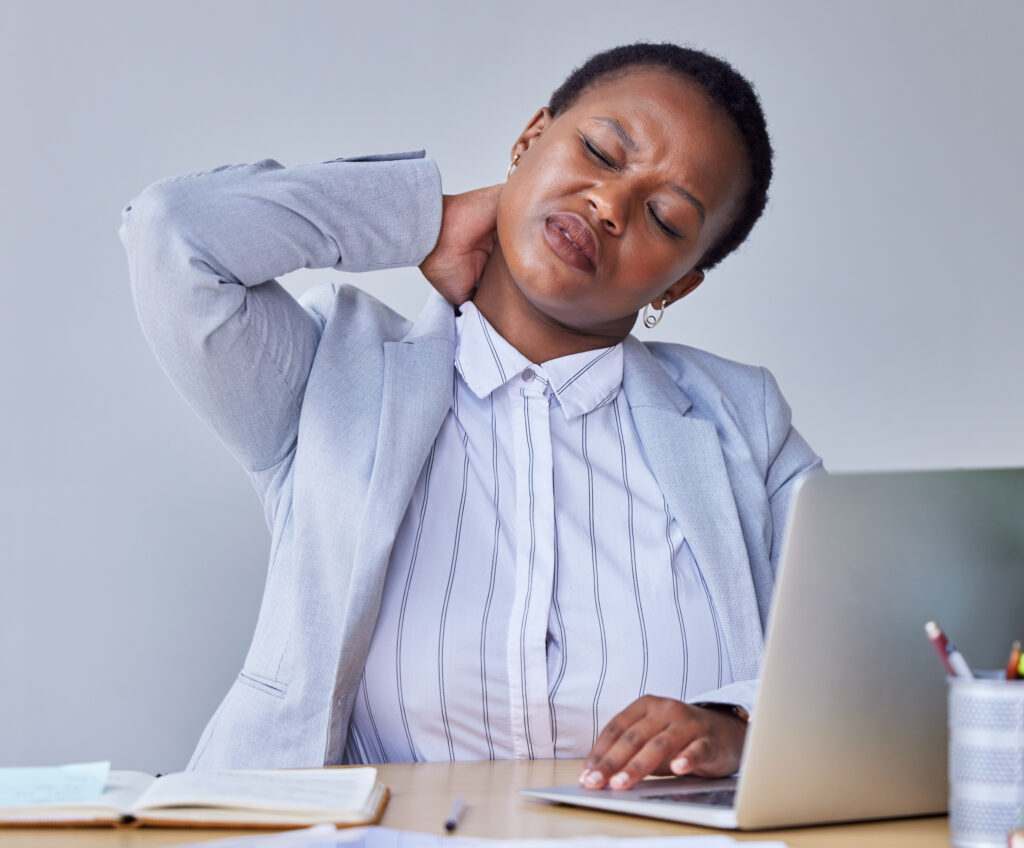 A woman leaning over and stretching her neck with a look of discomfort on her face