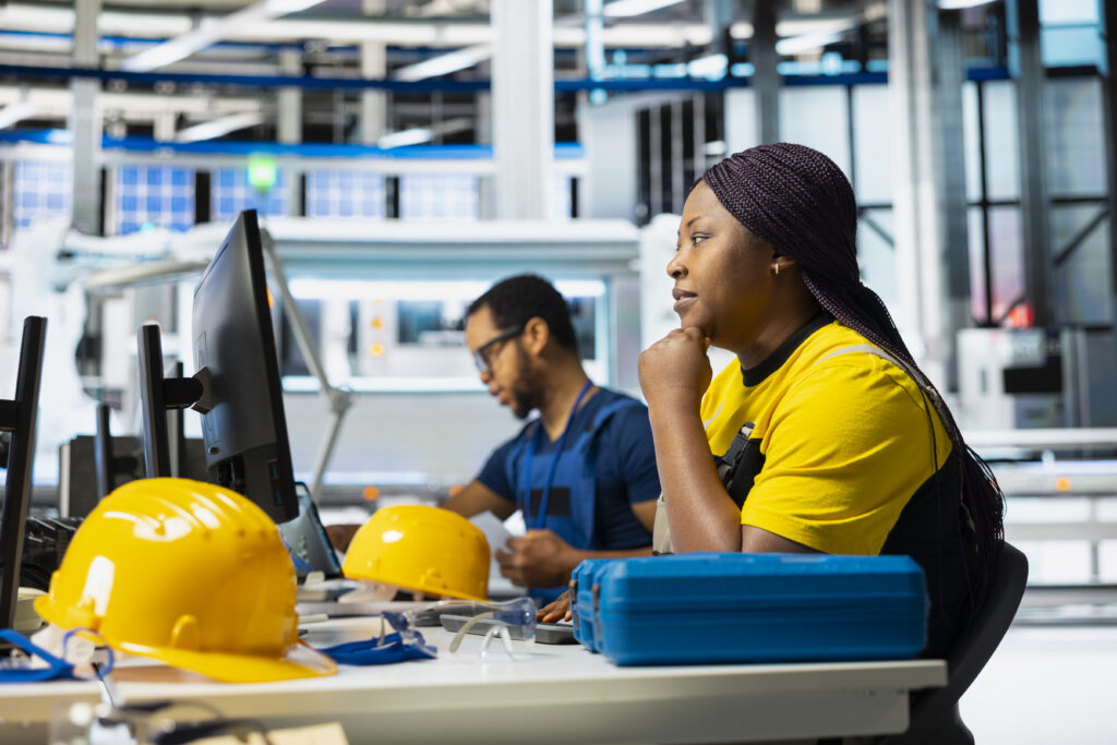 Two factory engineers optimising flow on their computers.