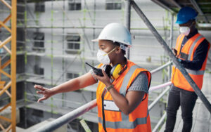 Two construction workers directing others.